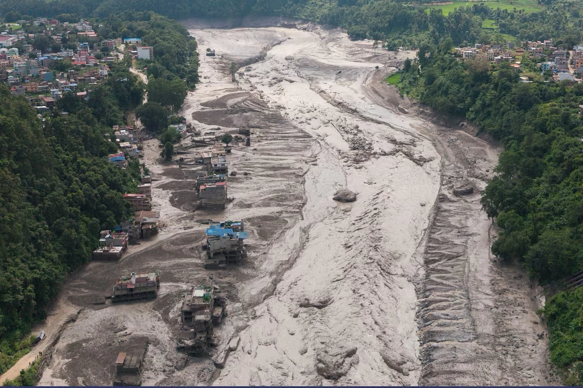 Rescuers carry victims of Nepal Tibet flash flooding along the Trishuli River in Nuwakot district as search operations continue for nearly 1,000 missing people.