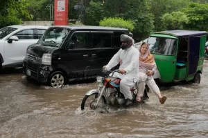 Monsoon rain in Pakistan today showing heavy rainfall in Lahore Punjab streets during the 2026 monsoon season with flooded roads and dark storm clouds.