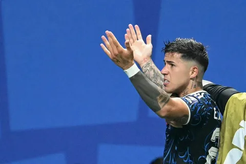 Enzo Fernandez holding Manchester City jersey after completing record transfer from Chelsea