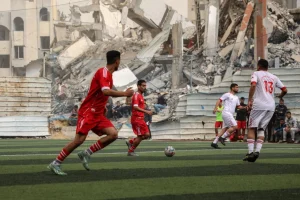 Palestinian football players and fans at Faisal Al-Husseini Stadium during the tournament opener